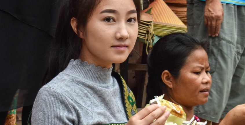 Early Morning villagers offer alms-giving to novice monks